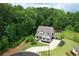 Aerial view showcasing the home, its manicured lawn, black landscaping, and its surrounding trees at 4383 Capstone Ne Ct, Roswell, GA 30075