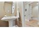 Stylish powder room features a pedestal sink and decorative mirror at 4383 Capstone Ne Ct, Roswell, GA 30075