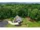 Aerial view of a home surrounded by lush greenery and a winding driveway at 4383 Capstone Ne Ct, Roswell, GA 30075