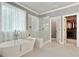 Bright bathroom with a soaking tub, walk-in shower, and view of walk-in closet at 4383 Capstone Ne Ct, Roswell, GA 30075