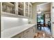 Beautiful butler's pantry with white cabinets and drawers with view into breakfast nook at 4383 Capstone Ne Ct, Roswell, GA 30075