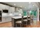Bright kitchen features stainless steel appliances, white cabinets, an island with seating, and a breakfast area at 4383 Capstone Ne Ct, Roswell, GA 30075