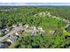 An aerial view of a home nestled among mature trees in a residential neighborhood with rolling hills at 995 Chimney Trace Way, Lawrenceville, GA 30045
