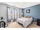 Well-lit bedroom with neutral carpet, large windows, and comfortable patterned bedding at 995 Chimney Trace Way, Lawrenceville, GA 30045