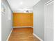 Neutral-toned hallway with laminate floors offers access to a room with orange accent wall at 995 Chimney Trace Way, Lawrenceville, GA 30045