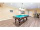 Basement area has a pool table under hanging lights and hardwood style flooring at 270 Annelise Park Dr, Fayetteville, GA 30214