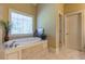 A bathroom showcases a relaxing soaking tub with natural light from the window at 270 Annelise Park Dr, Fayetteville, GA 30214