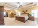 Large bedroom with a tray ceiling, neutral carpet, and wooden furniture; adjoining office is visible through doorway at 270 Annelise Park Dr, Fayetteville, GA 30214