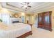 Bedroom featuring a tray ceiling, neutral carpet, fireplace, and wooden furniture; side door view at 270 Annelise Park Dr, Fayetteville, GA 30214