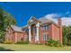 Side view of a two-story brick house featuring a well-maintained lawn and lush landscaping with multiple windows at 270 Annelise Park Dr, Fayetteville, GA 30214