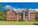 Elegant red brick home with a manicured lawn and symmetrical design, creating a welcoming and stately curb appeal at 270 Annelise Park Dr, Fayetteville, GA 30214