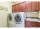 Well-organized laundry room with wooden cabinets, a sink, and modern washer and dryer at 270 Annelise Park Dr, Fayetteville, GA 30214