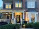 Charming brick home featuring a covered front porch with classic white pillars and manicured landscaping at 3250 Seven Oaks Dr, Cumming, GA 30041