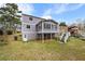 View of the backyard featuring a two-story home with a screened-in porch and stairs leading down to the yard at 4608 Rosemear Ct, Norcross, GA 30093