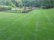 Expansive backyard and horse pasture featuring a well-maintained lawn, fencing, and various outbuildings at 605 Ga 120 Hwy, Roswell, GA 30075