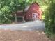 Exterior view of a red barn with white doors, stone trim, and a gravel driveway at 605 Ga 120 Hwy, Roswell, GA 30075