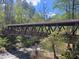 Exterior view of a picturesque covered bridge, surrounded by lush greenery and flowing river at Roswell Mill at 605 Ga 120 Hwy, Roswell, GA 30075