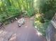 Spacious wooden deck featuring a table, grill, shed, and tranquil greenery views at 605 Ga 120 Hwy, Roswell, GA 30075