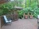 Wood deck featuring a chair, shed, and potted flowers surrounded by lush trees at 605 Ga 120 Hwy, Roswell, GA 30075