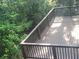 Wooden deck featuring dark brown railings and overlooking the landscaped yard at 605 Ga 120 Hwy, Roswell, GA 30075