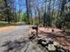 Private driveway leading to the property, featuring a mailbox, brick pavers, and mature trees at 605 Ga 120 Hwy, Roswell, GA 30075