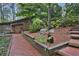 Charming home exterior featuring a brick pathway, rustic wood siding, and landscaped garden beds at 605 Ga 120 Hwy, Roswell, GA 30075