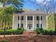 View of a stately colonial home with large columns, black shutters, and manicured hedges at 605 Ga 120 Hwy, Roswell, GA 30075
