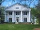 Colonial home with a white exterior, black shutters, large columns, and a well-manicured lawn at 605 Ga 120 Hwy, Roswell, GA 30075