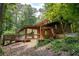 Inviting log home with a deck and lush landscaping creates a private and serene setting at 605 Ga 120 Hwy, Roswell, GA 30075