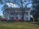 Elegant estate with white columns, green shutters, and blooming azaleas surrounding the property at 605 Ga 120 Hwy, Roswell, GA 30075