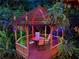 Enchanting gazebo with colorful lights creates a magical outdoor dining space surrounded by lush greenery at 605 Ga 120 Hwy, Roswell, GA 30075