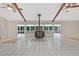 Open living room with beamed ceilings, wood-burning stove, and large windows overlooking the surrounding trees at 605 Ga 120 Hwy, Roswell, GA 30075