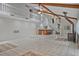 Spacious living room featuring high ceilings, beams, a wood-burning stove, a wet bar, and a staircase to the second floor at 605 Ga 120 Hwy, Roswell, GA 30075