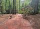 Brick pathway through lush greenery and mature trees offers a peaceful walking experience at 605 Ga 120 Hwy, Roswell, GA 30075