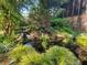 Landscaped backyard pond featuring rock waterfall, lush plantings and covered deck at 605 Ga 120 Hwy, Roswell, GA 30075