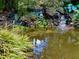 Picturesque backyard pond with stone waterfall feature, lush landscaping, and calming water sounds at 605 Ga 120 Hwy, Roswell, GA 30075