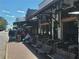 A view of the exterior of a restaurant with outdoor seating and sidewalk benches in a busy area at 605 Ga 120 Hwy, Roswell, GA 30075