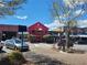 Exterior shot of a two-story restaurant with an outdoor balcony, on-street parking, and sidewalk access at 605 Ga 120 Hwy, Roswell, GA 30075