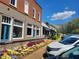 Street view of businesses with colorful flowerbeds enhancing the curb appeal and parked cars at 605 Ga 120 Hwy, Roswell, GA 30075