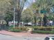 Charming town square featuring manicured landscaping, a red brick sidewalk, and mature shade trees at 605 Ga 120 Hwy, Roswell, GA 30075