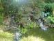 Beautiful backyard water feature with small waterfalls, a pond and mature plantings creating a relaxing Zen garden at 605 Ga 120 Hwy, Roswell, GA 30075