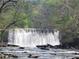 Scenic view of a flowing waterfall, nestled amongst the rocks and foliage in the historic Roswell Mill at 605 Ga 120 Hwy, Roswell, GA 30075
