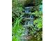 Multi-tiered backyard waterfall with natural stone and lush landscaped plantings at 605 Ga 120 Hwy, Roswell, GA 30075