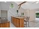 Wet bar with wood cabinets, barstool seating, and nearby staircase at 605 Ga 120 Hwy, Roswell, GA 30075