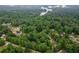 Aerial view showcasing the property's wooded setting with lake view and other neighborhood homes at 2865 Chattahoochee Rd, Cumming, GA 30041
