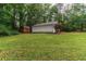 Spacious backyard featuring the home, a storage shed, and lush greenery, perfect for outdoor enjoyment at 2865 Chattahoochee Rd, Cumming, GA 30041