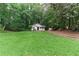 Expansive front yard view featuring a cozy home with a well-manicured lawn, set among mature trees at 2865 Chattahoochee Rd, Cumming, GA 30041