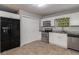 Well-lit kitchen featuring stainless steel appliances, white cabinets, and tile flooring at 2865 Chattahoochee Rd, Cumming, GA 30041