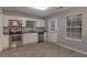 Modern kitchen with stainless steel appliances, white cabinets, and tile flooring, ideal for cooking at 2865 Chattahoochee Rd, Cumming, GA 30041