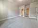 Spacious bedroom featuring neutral walls, white trim, and carpet flooring with views to the bathroom and closet at 5702 Urban Village Way # 2, Tucker, GA 30084